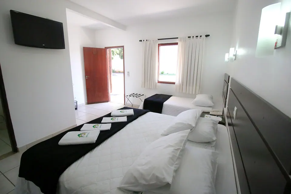 Room with a double bed and a single bed at Pousada Remanso